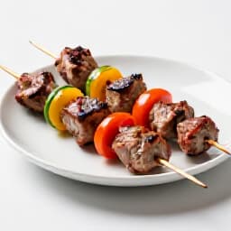 Exquisite Armenian Shish Kebab on an A La Carte Menu. Close-up of perfectly grilled shish kebab, showcasing tender meat and vibrant vegetables, representing Beluga Restaurant