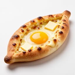 Freshly baked Khachapuri Adjaruli in San Francisco. A boat-shaped Georgian cheese bread with a rich egg yolk and butter, perfectly baked with a golden crust, ready to be enjoyed.