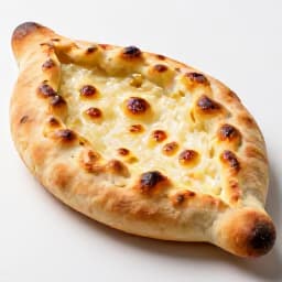 Traditional Armenian Khachapuri Imeruli, a round cheese-filled bread with a soft interior and slightly crispy exterior, served fresh at Beluga Restaurant in San Francisco.
