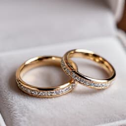 Elegant wedding rings symbolizing commitment. Close-up view of two wedding rings intertwined on a textured surface, representing love and partnership for wedding receptions at Beluga Banquet Hall in San Francisco.